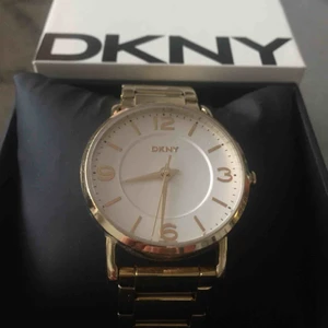  - Enkel och stilren guldklocka från DKNY. Använd och i bra skick, men med några repor på uret samt på armbandet. Länk till armbandet för att göra den större finns.   Köparen betalar frakt annars kan köp göras i Göteborg.