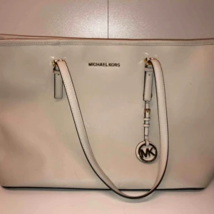  - Äkta Michael Kors väska i en beige färg med guldetaljer. Nypris: 3500kr