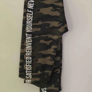  - Camouflage-leggings från Bershka med text på sidorna. Aldrig använda. 