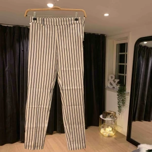  - Högmidjade tajta vit- och svartrandiga byxor från hm. Stretchiga och snygga. Använda endast en gång!