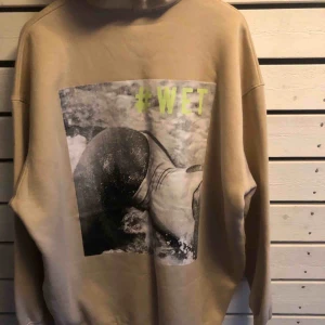 - Oversized beige hoodie med stort tryck på ryggen.  Storlek S men som sagt oversize så passar flera storlekar