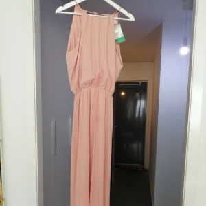 Ljusrosa satin klänning  - Oanvänd med prislapp kvar på. Inköpt:499kr, säljer för 120kr