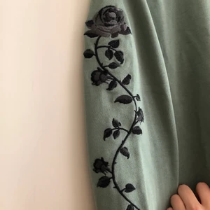 NA-KD tröja - En ljusgrön oversized tröja från NA-KD med svarta rosor på båda armarna. Använd max 3 gånger. Inte min stil längre! Storlek S men passar XS och M beroende på hur man vill ha fiten