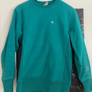 Championtröja - Collegetröja/sweatshirt från Champion i blågrönt! Står att det är medium, men sitter mer som en S skulle jag säga. Väldigt bra skick utan fläckar eller andra defekter. 🌞🙏🏼🌸