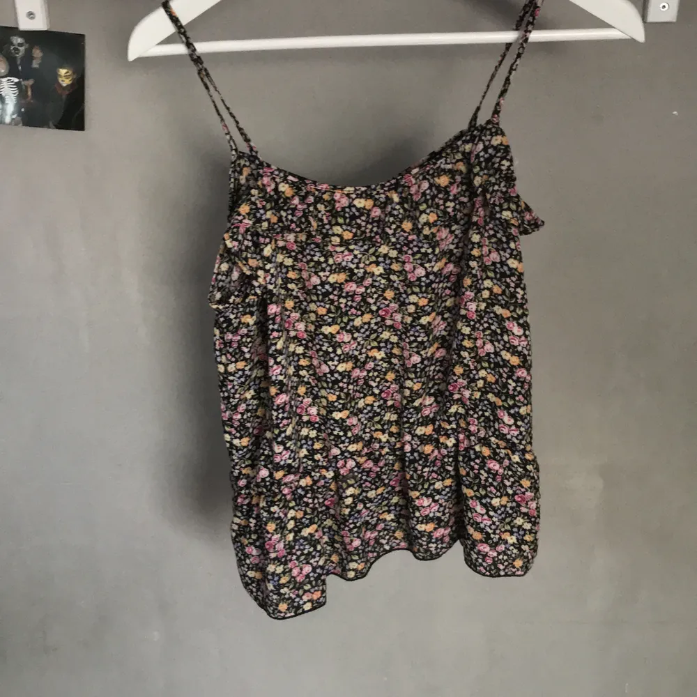 Sött linne med små blommor och volanger upptill/nertill på, står strl L men den är inte strech. Jag skulle bedöma den som M/L tunt material bra på sommaren. Puserot.