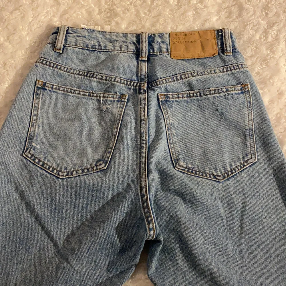 Slitna jeans från Pull&Bear i storlek 32 💙💙 Jeansen har mom-fit och har fina slitningar i form av stjärnor ⭐️ Dem är i mycket fint skick och är använda max 1 gång! Samfraktar gärna med andra plagg och betalning sker via Swish <33. Jeans & Byxor.