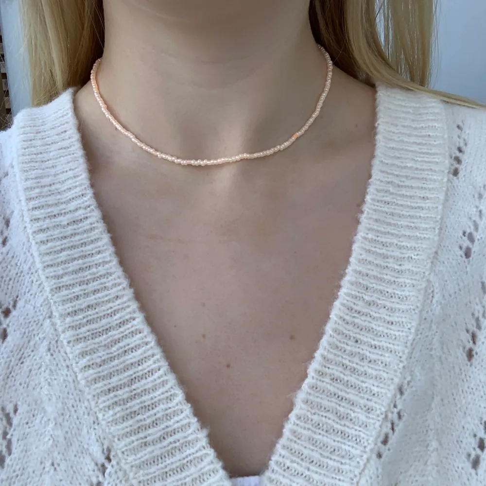 Pärlhalsband i en peach/orange färg med små pärlor🧡💫🥺 halsbandet försluts med lås och tråden är elastisk . Accessoarer.