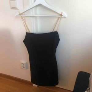  - Supercool svart klänning med guldkedja som ärmar. Aldrig använd, från Elsas kollektion med BikBok