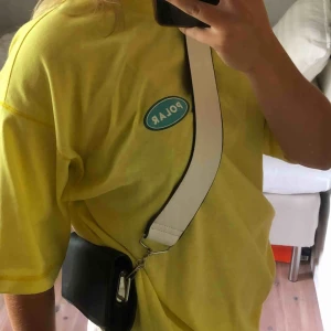  - Liten väska från Carin Wester med vitt band som man kan vända så det blir blått. Liten innerficka. Mycket bra skick! Köparen står för frakt