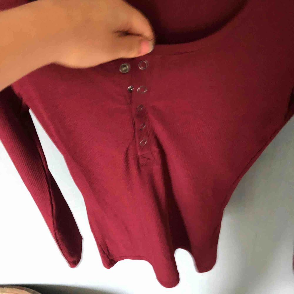 Långärmad vinröd tröja med knappar, går att knäppa helavägen upp eller ha lite uppknäppt . Toppar.