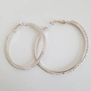  - Ett par hoops i silver med små diamantliknande stenar runt hela. Mycket fina och glittrar vackert i solen. Nickelfria. Köparen står för frakten (9kr)!🌻