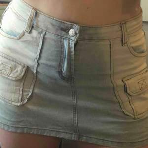 Kort kjol i jeansliknande tyg. Stretchig med 4 stora fickor och 2 små. Köpt på second hand i Berlin! Har en liten slits på båda sidor.