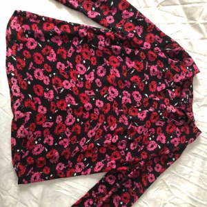  - Blus med röda och rosa pussmunnar