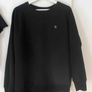 - En svart tröja med tryck på ryggen!!  Liten i storleken, jag som bär S i vanliga fall kan ha denna utan problem! Jag står för frakten!  Hör av er om ni är intresserade!🤗