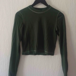  - Glittrig, grön midjetröja från Weekday. Tunt material och lite genomskinlig. Fraktkostnad tillkommer, kan också mötas upp i Malmö.