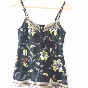  - Linne i satin med justerbara band. Dekorationsknappar fram och bred resår bak. 