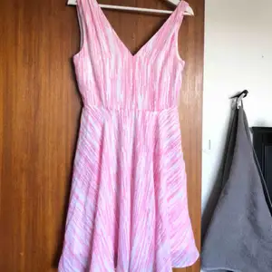 Somrig klänning i vitt och rosa mönster💕  Kort modell med en fin V-ringning både bak och fram. Använd en gång på skolanvslutning💞