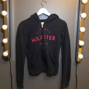  - Mörkblå hollister kofta med rosa tryck Lite urtvättad men annars i bra skick