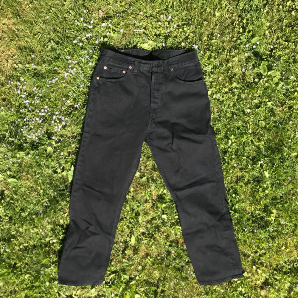 Ett par svarta Levis 501 jeans som är nästan helt oanvända. Enda problemet är att knappen högst upp i midjan saknas, det är möjligt att få fixat. Midjans bredd är ungefär 39cm och innerbenets längd är 75cm Spårad frakt = 58kr. Jeans & Byxor.