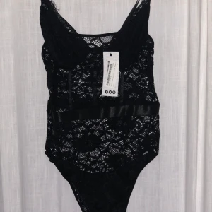Svart spetsbody - Oanvänd svart spetsbody i strl M känns mer som en strl S. Bra stretch 