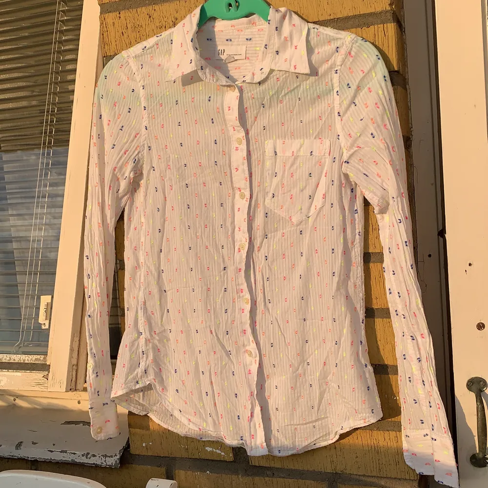 En jätte fin GAP skjorta i vit färg med neon rosa,neon orange och mörk blå prikar kan man säja. den är i storlek XXS men går också till S storlek, Säljer den för köpte fel storlek . Ny pris 220. Muu.