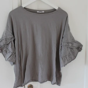 Grå topp - Grå topp med volang ärm. Köparen står för frakt🤍
