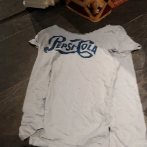 Blå Pepsi cola tröja  - Vi har klippt upp halsen så just nu sitter den lite mer off shoulder. Köparen står för eventuel frakt och kan hämtas i GBG. 