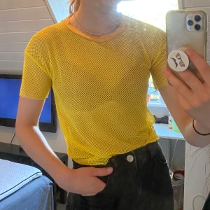 Gul nät t-shirt - En gul t-shirt av nätaktigt material. Har snygg passform och sitter bekvämt. 