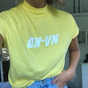 NAKD T-shirt  - Ljusgul T-shirt från NAKD i nyskick. Kort ärm och liten polokrage. Passar mig som är en S/M i vanliga fall. Säljer pga kommer inte till användning.