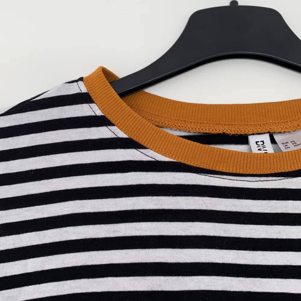 En super cool svart och vit randig tröja från divided med orangea detaljer!💥⭐️💫. Tröjor & Koftor.