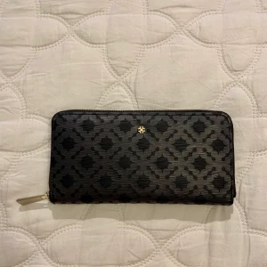 DAY BIRGER ET MIKKELSEN plånbok - Plånbok Day Linger Purse 12000 Black i snyggt mönster från DAY BIRGER ET MIKKELSEN. Plånboken har:  - Myntfack som försluts med dragkedja - Plats för 8 kort Längd 19,5 cm, bredd 2 cm, höjd 10,5 cm. Använd 2 gånger. Nypris 500 kr.