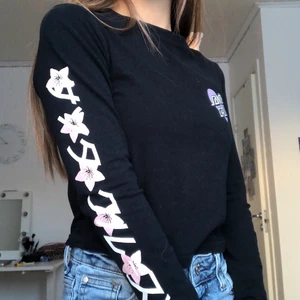 Svart tröja med tryck - Jättefin långarmad tröja med blommigt tryck på ena armen. Använd ett fåtal gånger, men säljer då den inte är min stil längre. Fri från fläckar och skador. Köpt på Urban Outfitters. Storleken är S, men skulle säga att den passar från XS till liten M beroende på hur man vill att den sitter☺️ Frakt tillkommer💓