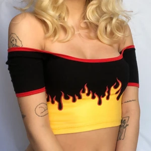 ✨Flame top✨ - Svart off the shoulder croptop med eld-mönster och röd detalj🔥 storlek är s men skulle säga den passar bäst på xs-s inte s-m då materialet inte är så stretchigt🔥 använd ett fåtal gånger så i basically nyskick🔥 frakt ingår ej utan kostar 42kr🔥 skriv om det finns några frågor🔥
