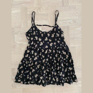 Blommig klänning Brandy Melville - Blommig kort klänning (för under typ 160cm) men funkar även som tunika eller längre linne. Från Brandy Melville. Passar S/M.