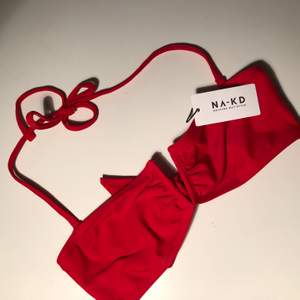 Röd bikiniöverdel från Na-kd. Säljer pga att den aldrig kommit till användning, därav har den lappar kvar. 