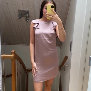 Klänning från hm med öppen rygg - Så fin Klänning i satin från hm med öppen rygg med volanger. Storlek 36. Knappt använd 