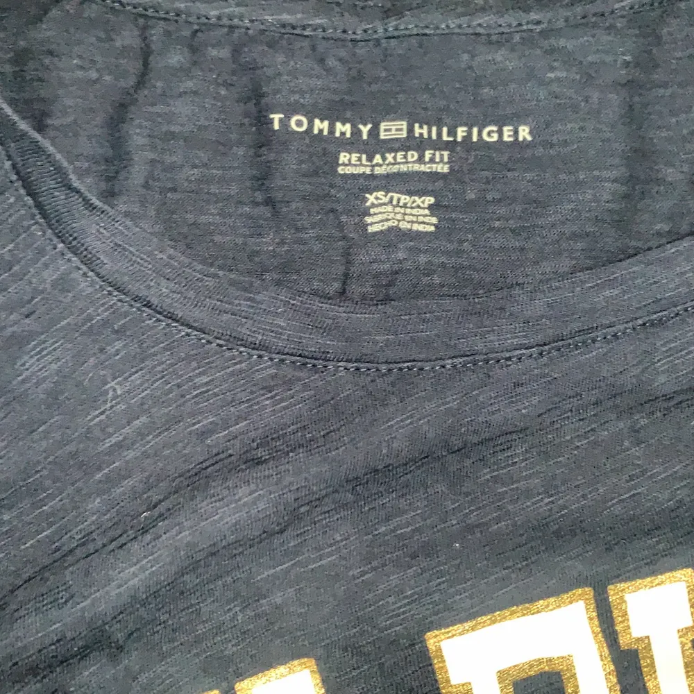 En mörkblå Tommy hilfiger t-shirt med vit/guldig text. Storlek XS och är i väldigt bra skick, inga fläckar.  . T-shirts.