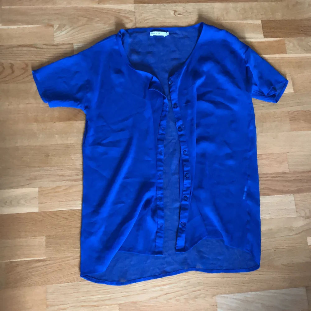 Blå kortärmad skjorta, lite genomskinlig från ONLY stl 38. Lös passform. . Skjortor.