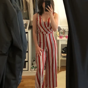 Randig dress - En randig dress med omlott framtill, v-ringad och knytning baktill.Från Bershka. Sitter skit najs är i väldigt bra skick, använd 1-2 gånger.