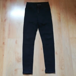 KappAhl Svarta Jeans strl 36 - Svart jeans med stretch från KappAhl i storlek 36. Använda 3 gånger och säljs pga. fel storlek. Har ej börjat blekna eller något liknande. Har dragkedja och knapp, samt fickor bak och fram. 75% Bomull, 23% Polyester och 2% Elastan. Pris + inkl. frakt. 