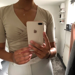 Topp - Beige topp från MQ. Aldrig använd, nyskick. Toppen är i storlek S och går omlott framtill. 100 kr + frakt. 