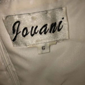  - Vit aftonklänning med blomdetaljer 🌸 jovani stl 6, passar s.