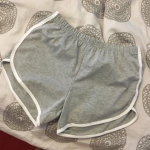  - **OANVÄND** Mjuka shorts, gråa med vit rand på sidan 