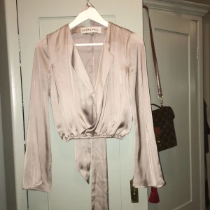  - Sidenblus från Ivyrevel i gammelrosa/ biege färg med "trumpetärm" .Tilllhörande sjal som går att tex knyta i midjan eller ha runt halsen. använd endast en gång. 