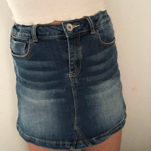  - En blå jeans kjol med slitning på sidan, strl är som s/xs