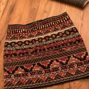  - Snygg kjol från H&M med pärlor och broderier. Aldrig använd, prislapp kvar. Helsvart på baksidan.  Köparen betalar frakten. 