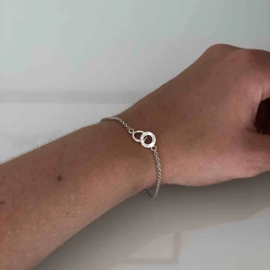 - Jättefint Evfa Attling armband, nästan aldrig använt. På en av ringarna står det ”Amor vincit omnia” vilket betyder ”kärlek övervinner allt”. Äkta silver, ambandet kan bli 17cm eller 19cm. Orginalpris 900kr. Köpare står för frakt, betalning via swish. 