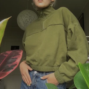 WEEKDAY croppad tjocktröja - En mörkgrön tjocktröja från Weekday, croppad, i fleece. Dragkedja vid halsen. Jättefin men tyvärr inte min stil! Frakt ingår i priset.