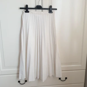 Midi tenniskjol - Vit plisserad midi tenniskjol i storlek XS. Frakten är inkluderad i priset.