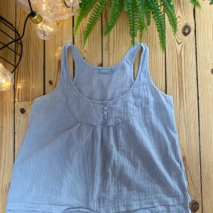 Grått linne - Jättegulligt grått linne med knappar! Fint att knyta upp tycker jag! Säljer då den aldrig kommer till användning tyvärr! Skulle säga att den passar en Xs-M🥰frakt tillkommer! Bara att skicka om du har några fler frågor eller vill ha fler bilder!❤️